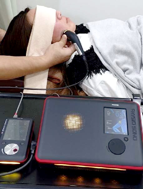 顔に超音波治療機器を当てている施術